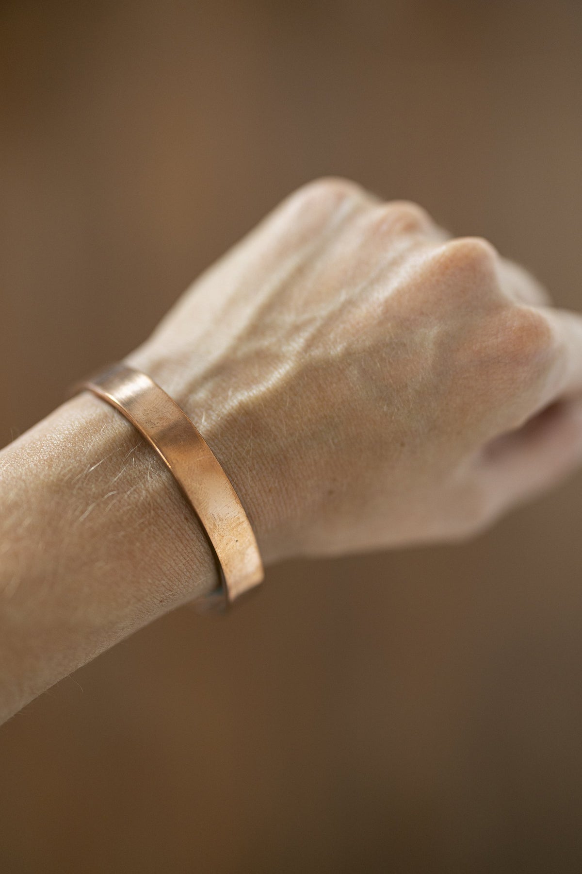 Pulsera de Cobre Kopero Lisa en la muñeca, primer plano del brazalete plano de cobre