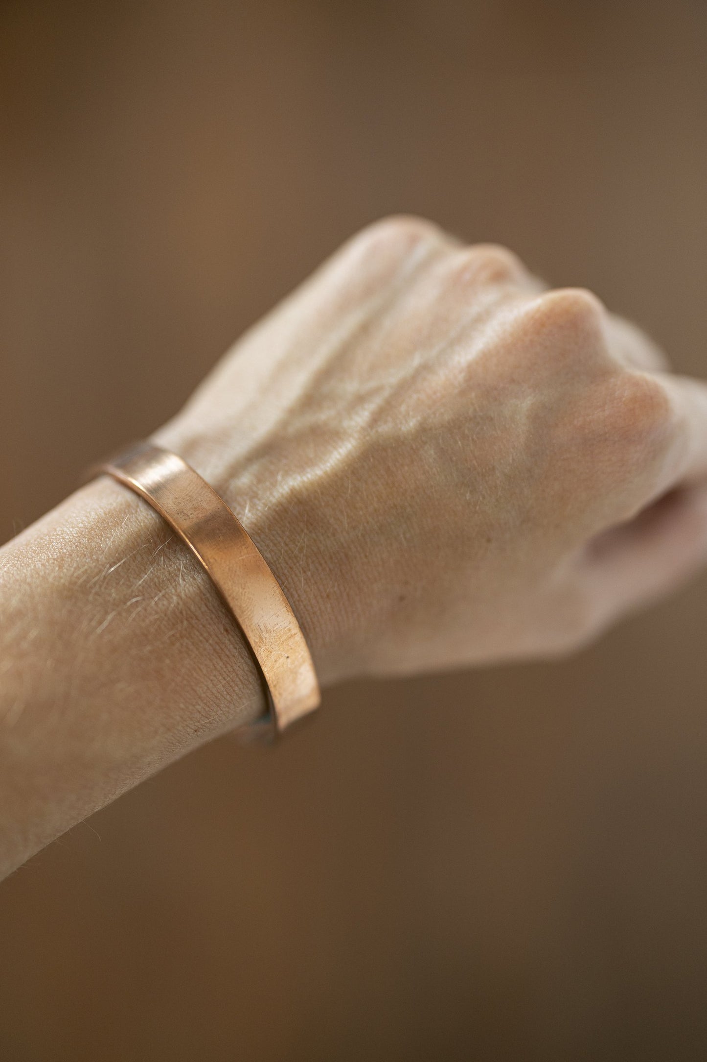 Pulsera de Cobre Kopero Lisa en la muñeca, primer plano del brazalete plano de cobre