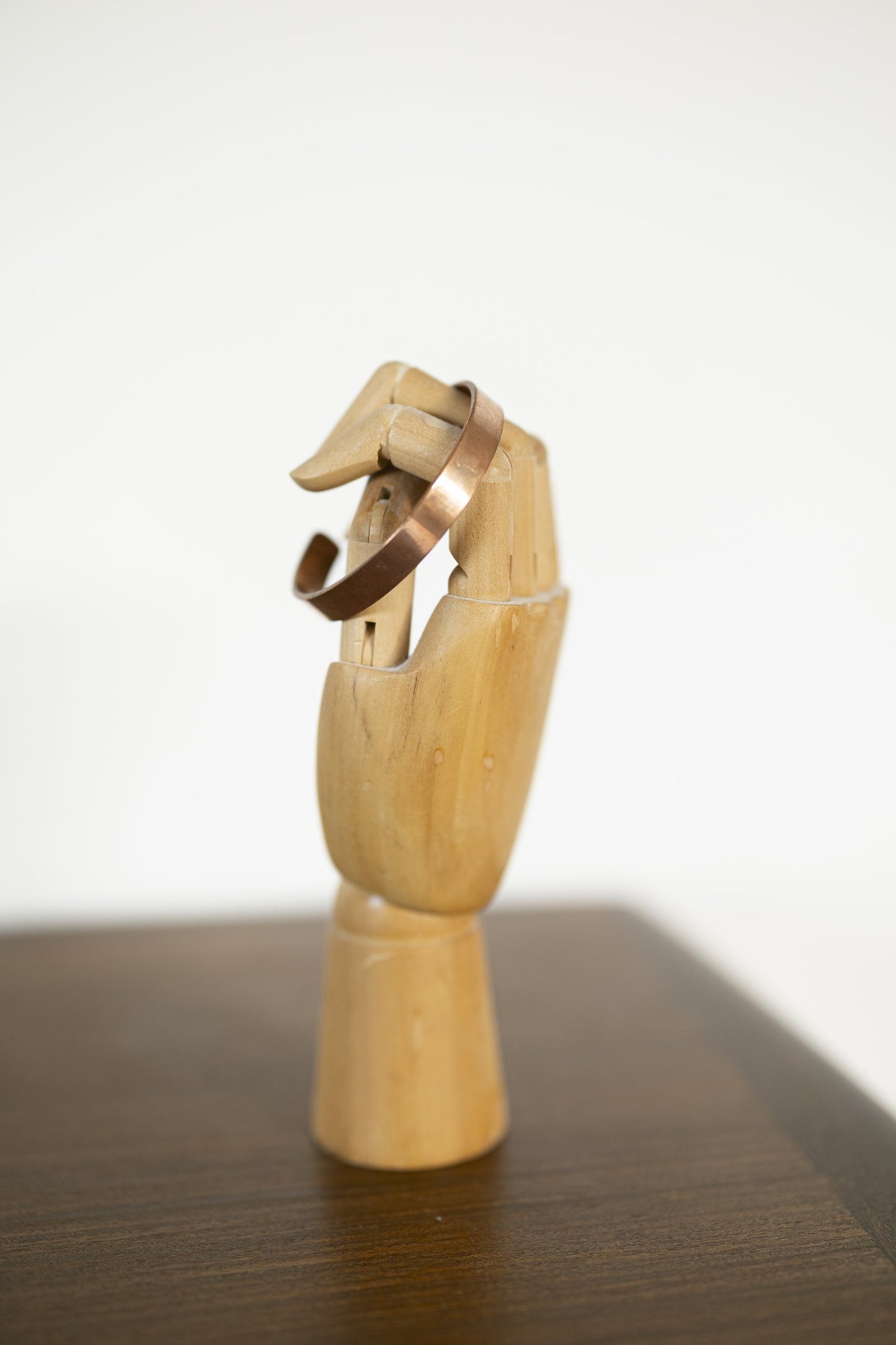 Pulsera de Cobre Kopero Lisa sobre un maniquí de mano de madera para joyería