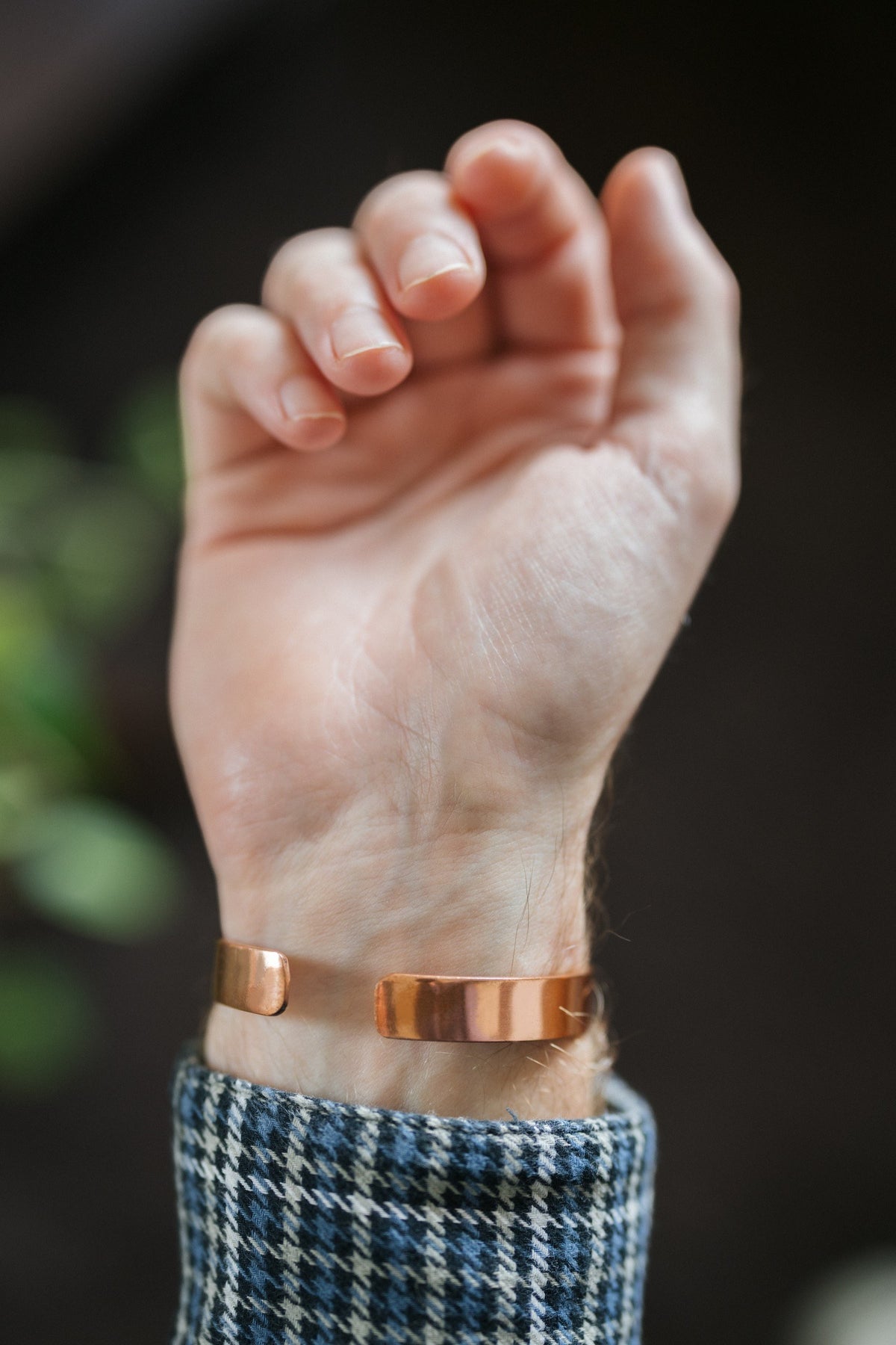 Pulsera de cobre Kopero Liso, en la muñeca, con la mano abierta y los extremos de la pulsera visibles