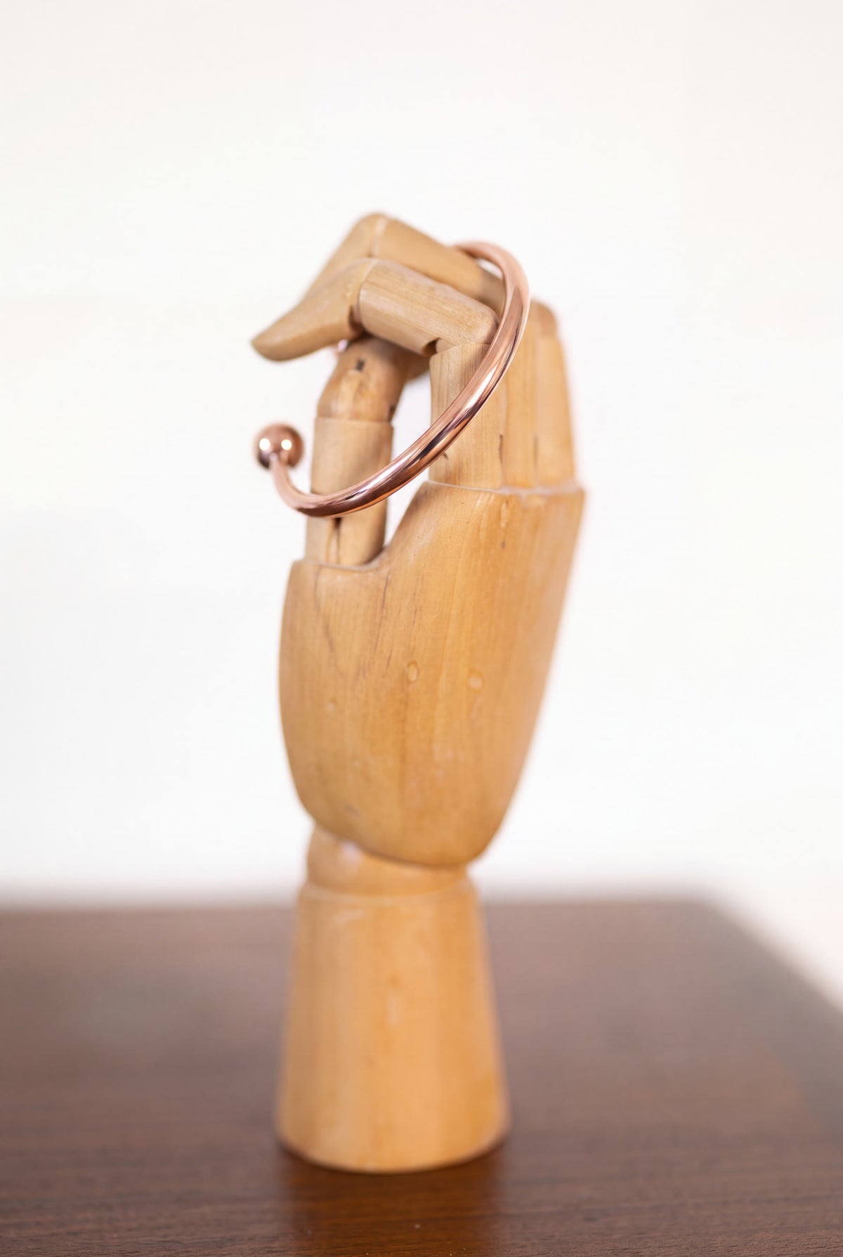 Kopero Koperen Armband Rond op een houten sieradenhand