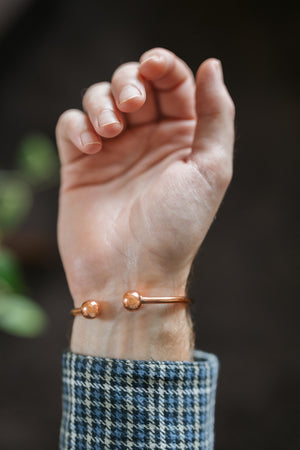 Pulsera de cobre Kopero Redondo, en la muñeca, con las dos bolitas de los extremos visibles
