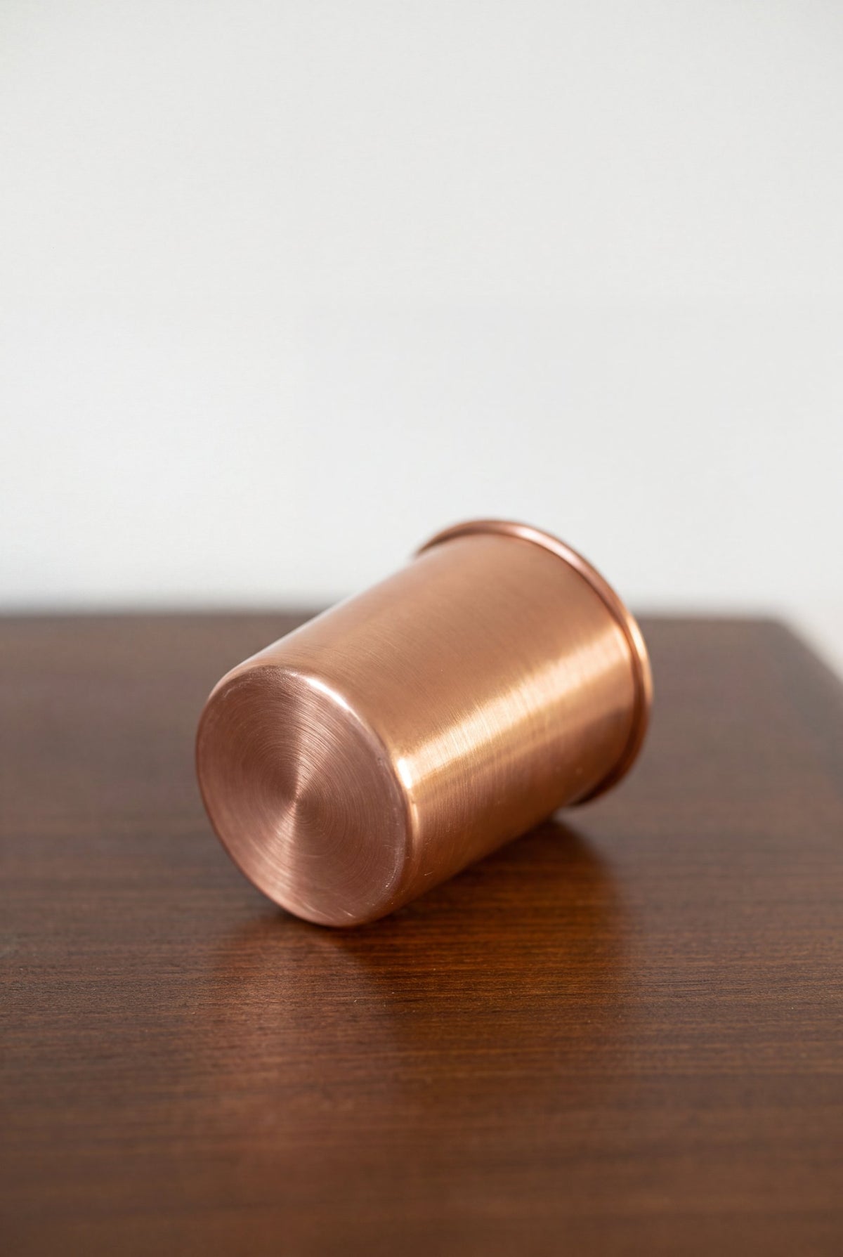Vaso de Cobre Kopero Liso tumbado sobre una mesa de madera