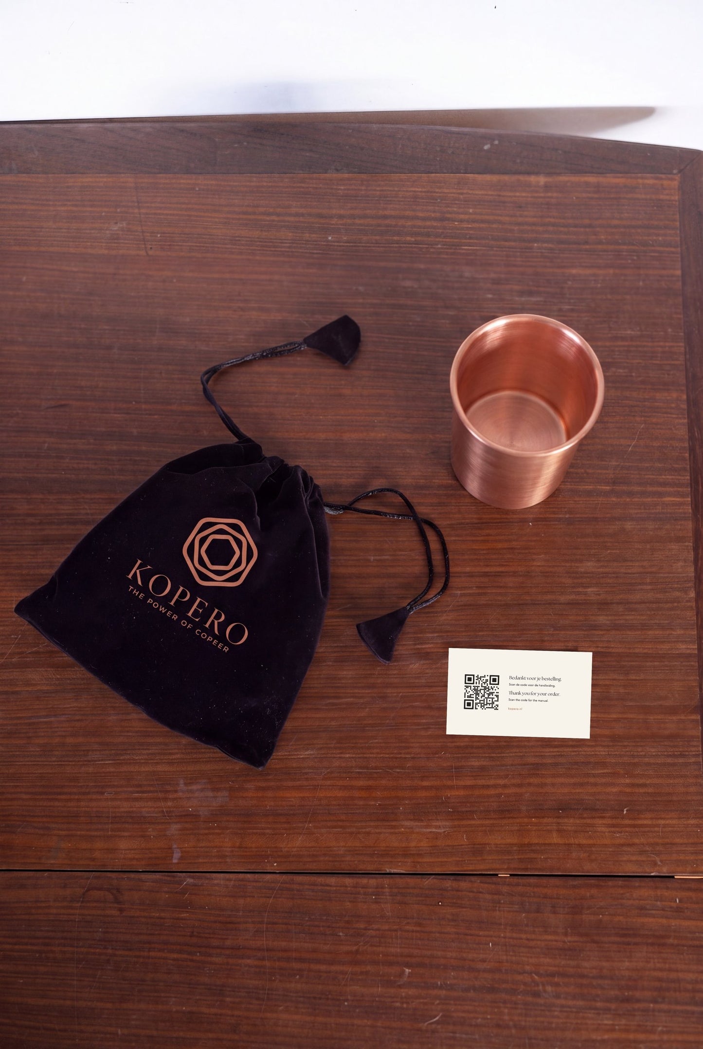 Vaso de Cobre Kopero Liso visto desde arriba con la bolsa de terciopelo y la tarjeta de agradecimiento