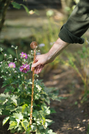 Electrocultivo Kopero 60 cm, una mano introduce la antena en el parterre