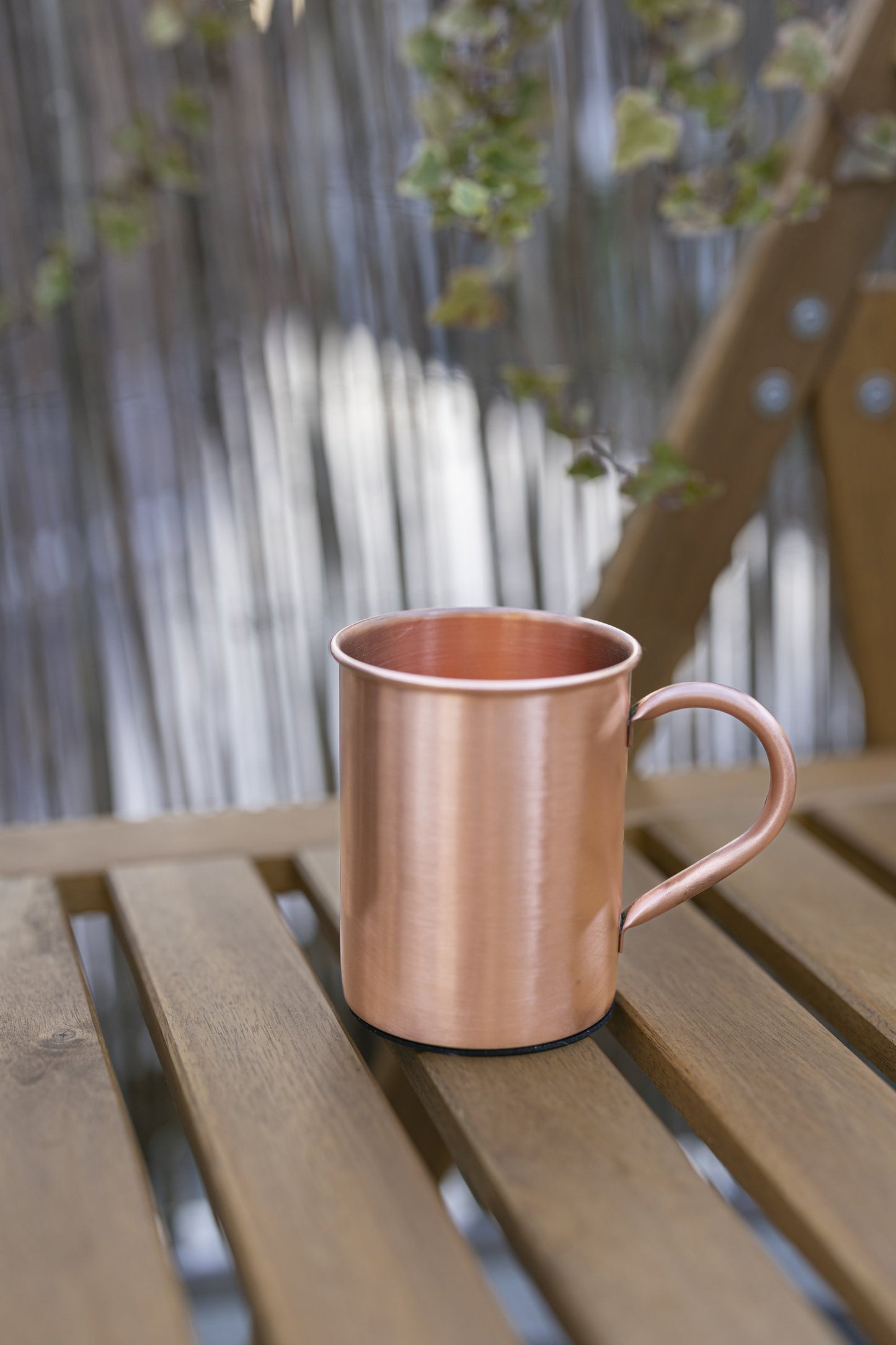 Taza de Cobre Kopero Lisa de 400 ml sobre un banco de jardín de madera