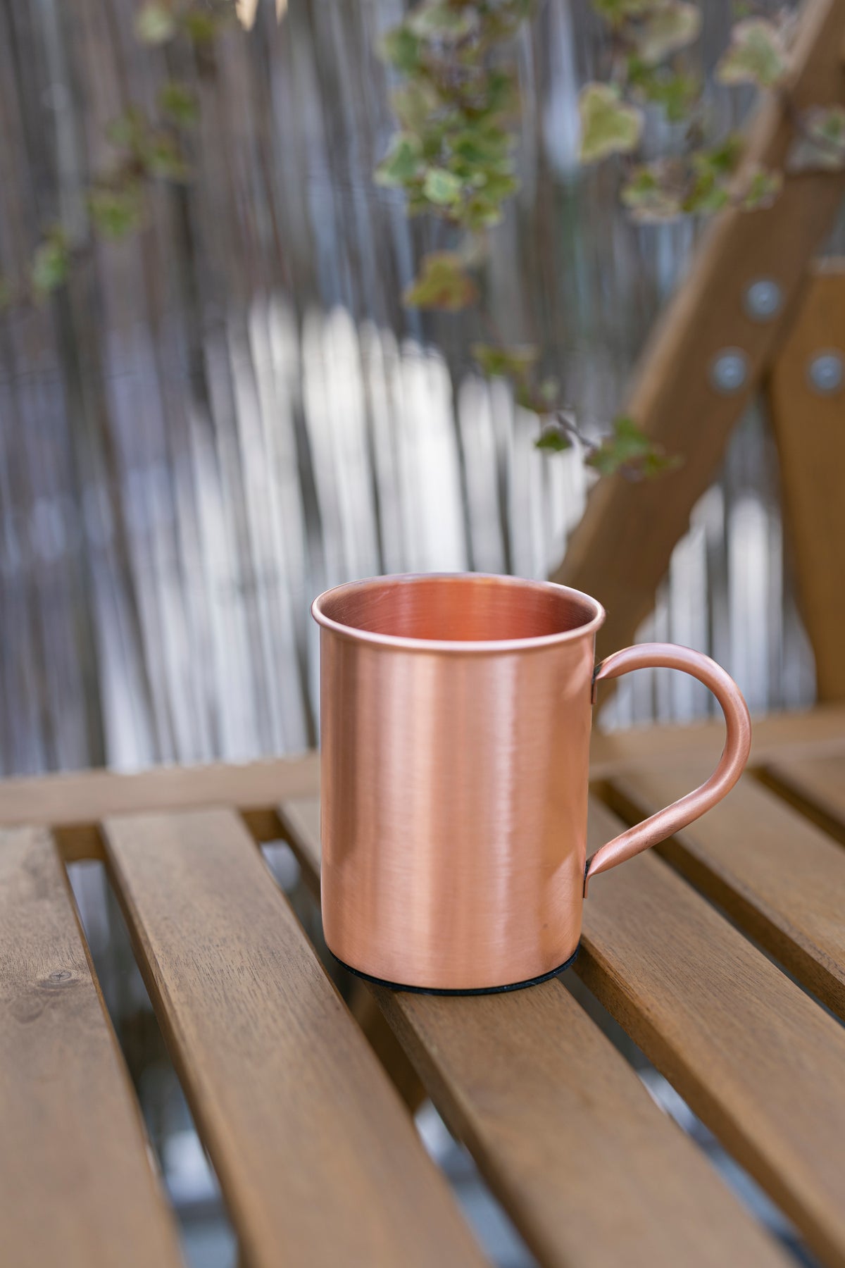 Taza de cobre Kopero Premium Lisa, 400 ml, 100% cobre puro, al aire libre sobre una mesa de jardín de madera