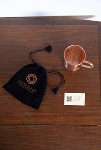 Taza de Cobre Kopero Lisa vista desde arriba con la bolsa de terciopelo y la tarjeta de agradecimiento