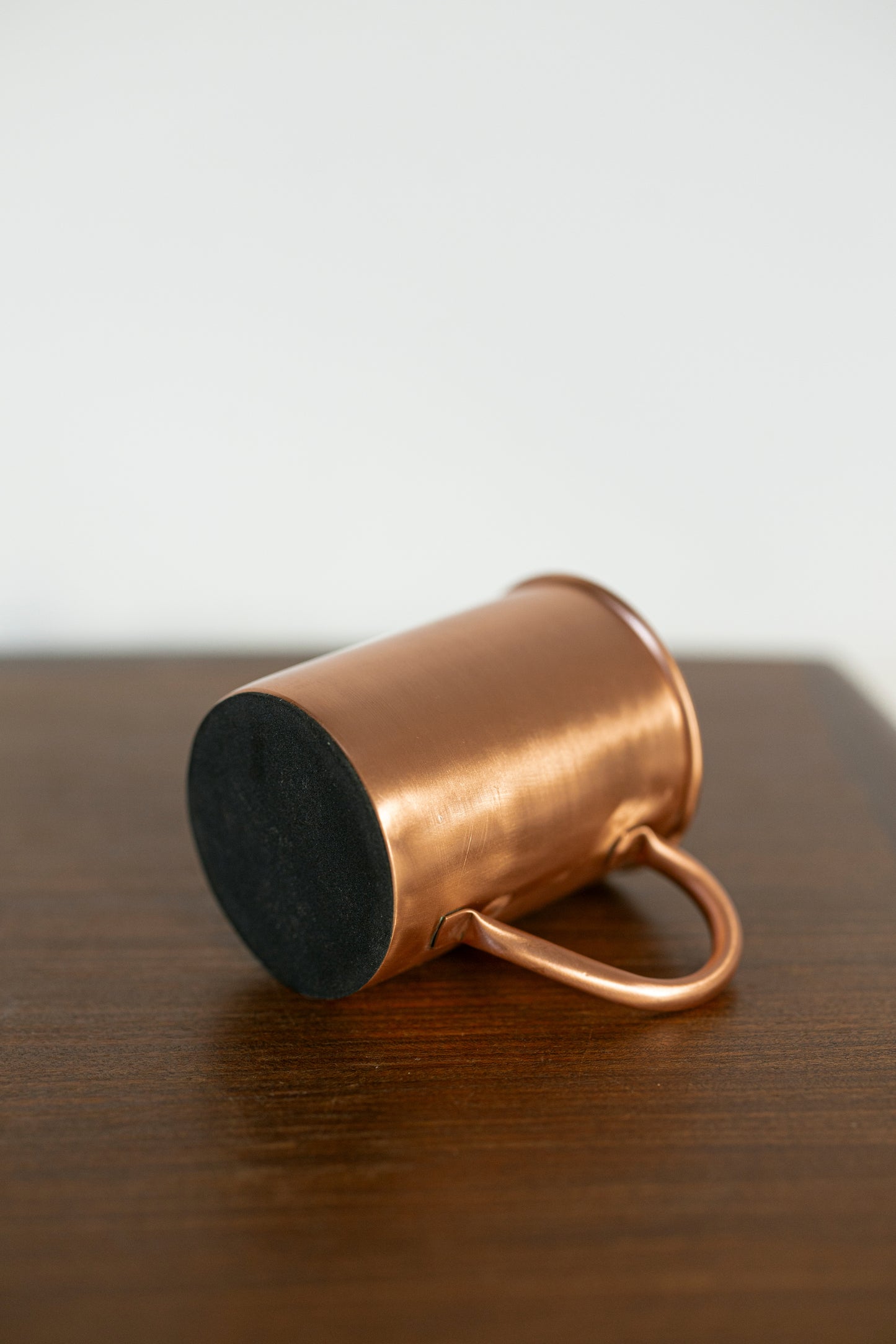 Taza de cobre Kopero Premium Lisa tumbada, con la base de fieltro visible