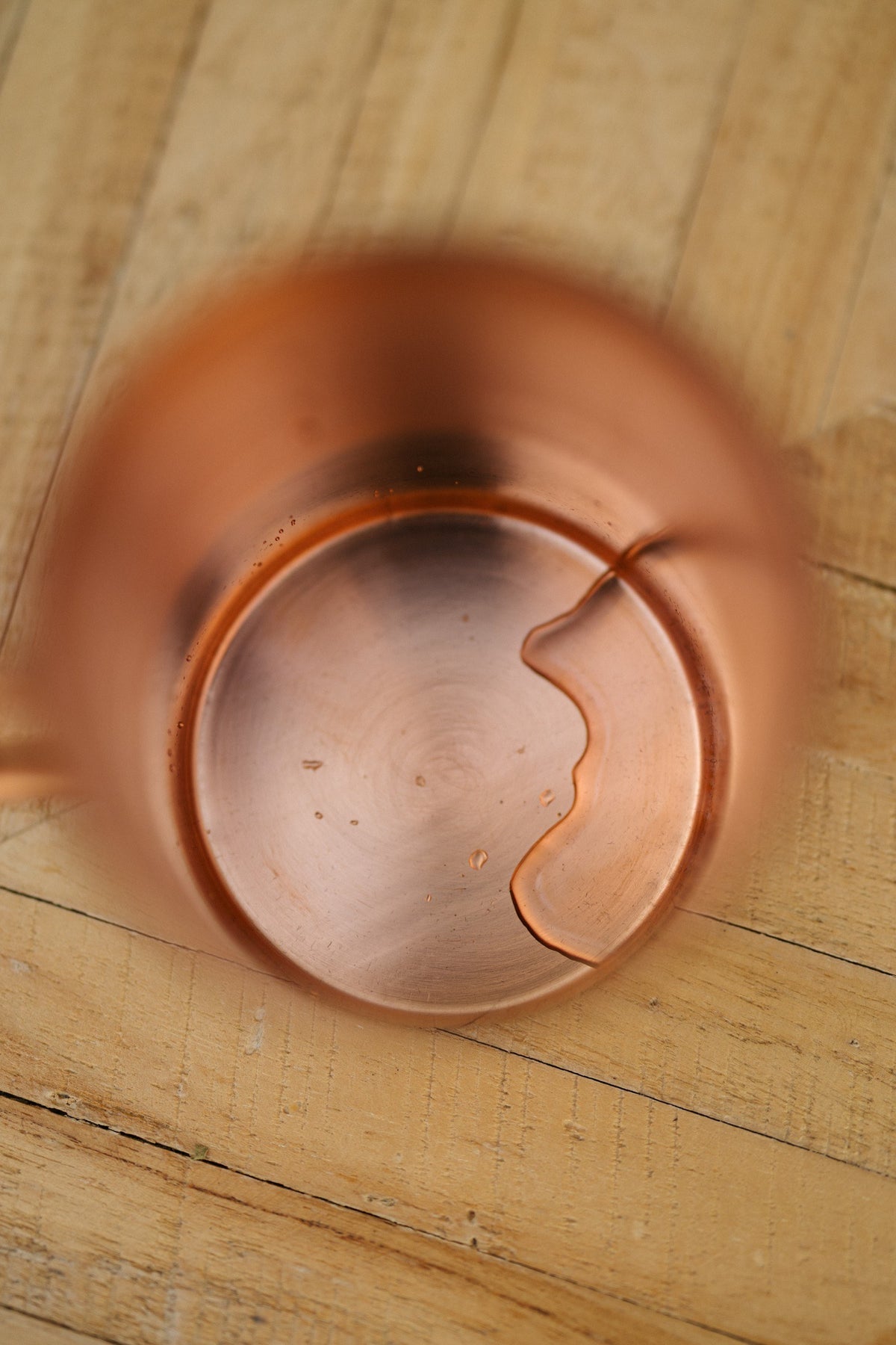 Taza de cobre Kopero Liso, visto desde arriba: el interior de la taza sobre una mesa de madera