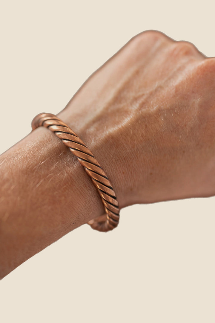 Pulsera de cobre Kopero Trenzado, en la muñeca, foto de producto sobre fondo blanco