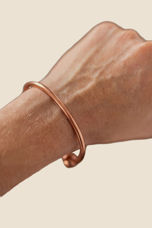 Pulsera de cobre Kopero Redondo, en la muñeca, foto de producto sobre fondo blanco