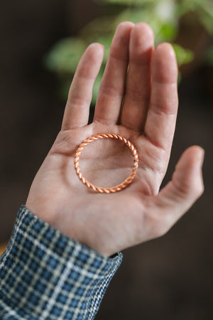 Anillo tensor de cobre Kopero, sobre una palma abierta