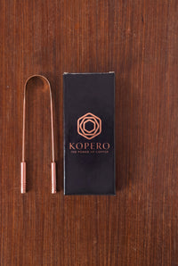 Raspador Lingual de Cobre Kopero junto a la caja de regalo negra